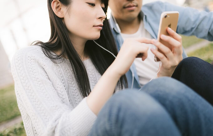 携帯を使う女性と男性